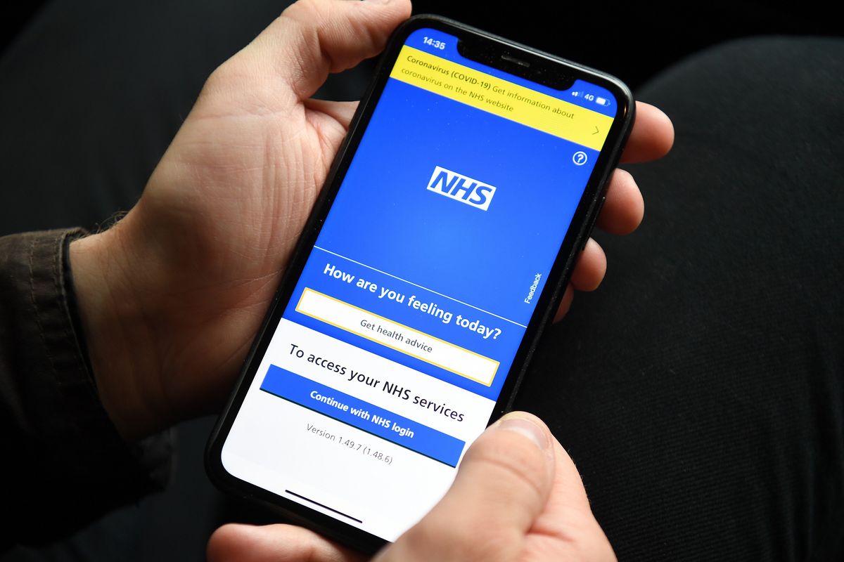 Man holding a phone with the NHS app