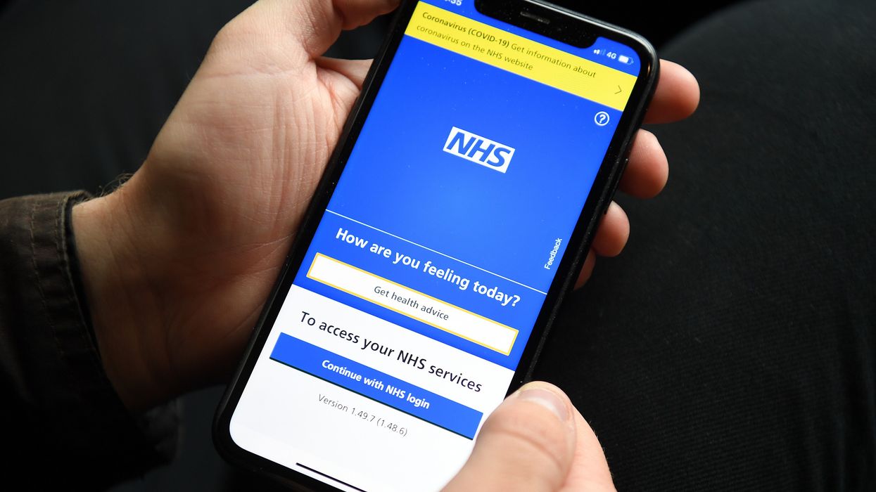 Man holding a phone with the NHS app