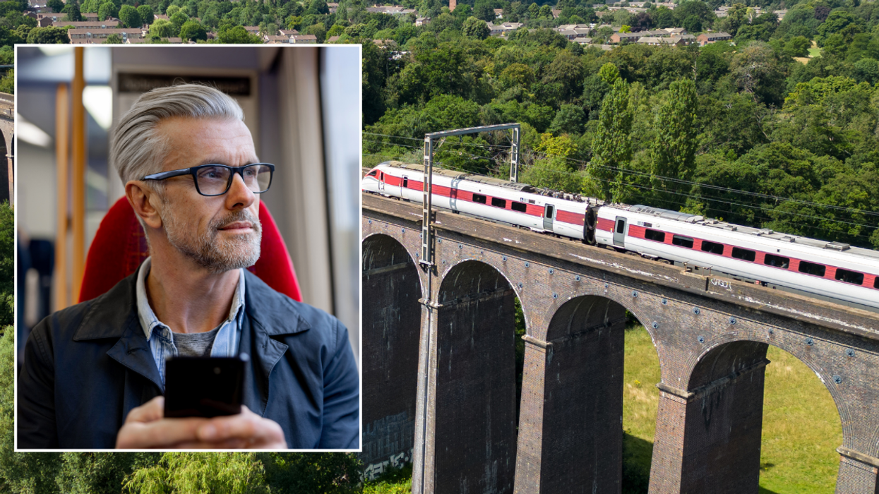 Man holding phone on train / train going over bridge in UK