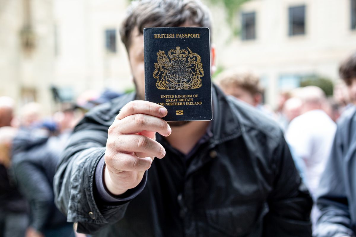 Man holding up British passport