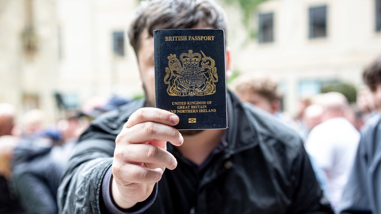 Man holding up British passport