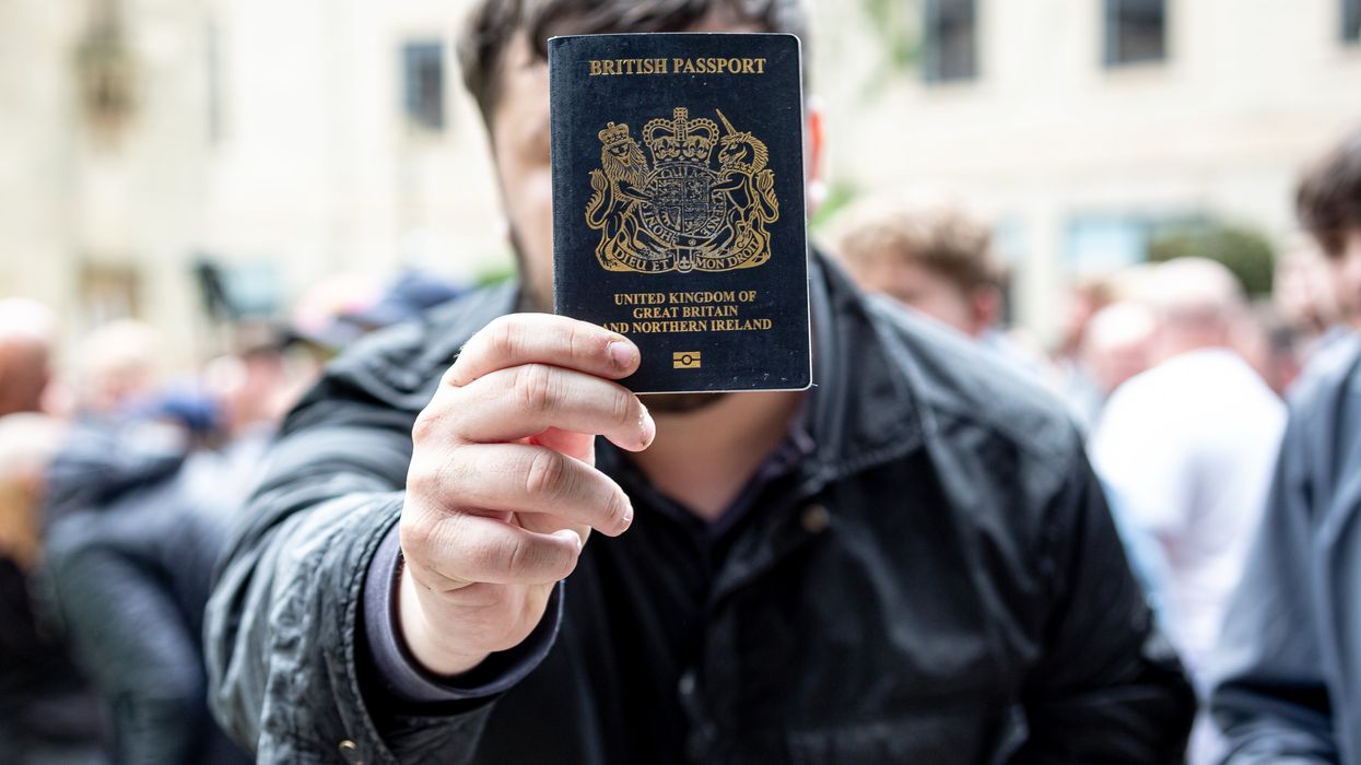 Man holding up British passport