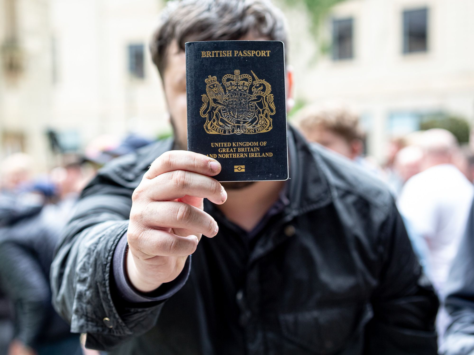 Man holding up British passport