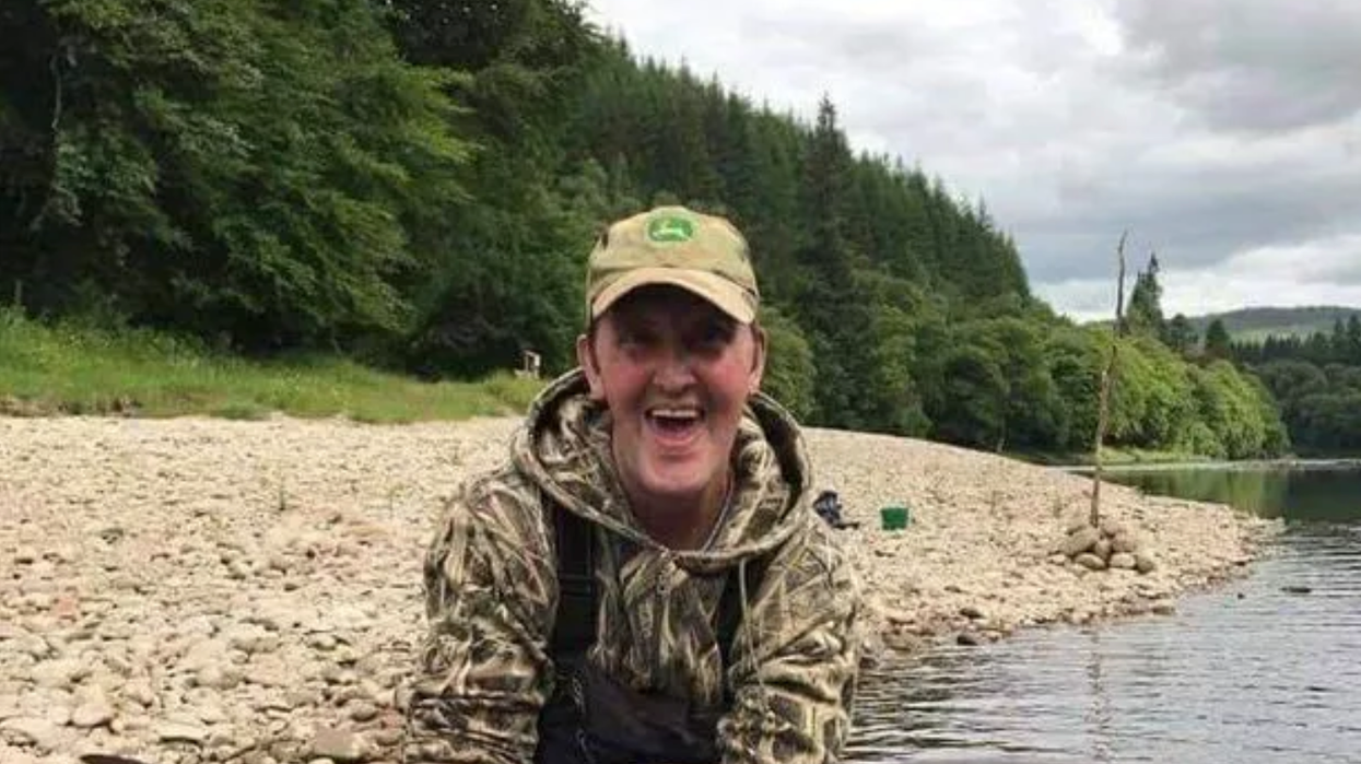 Man holds large fish on fishing trip in lake