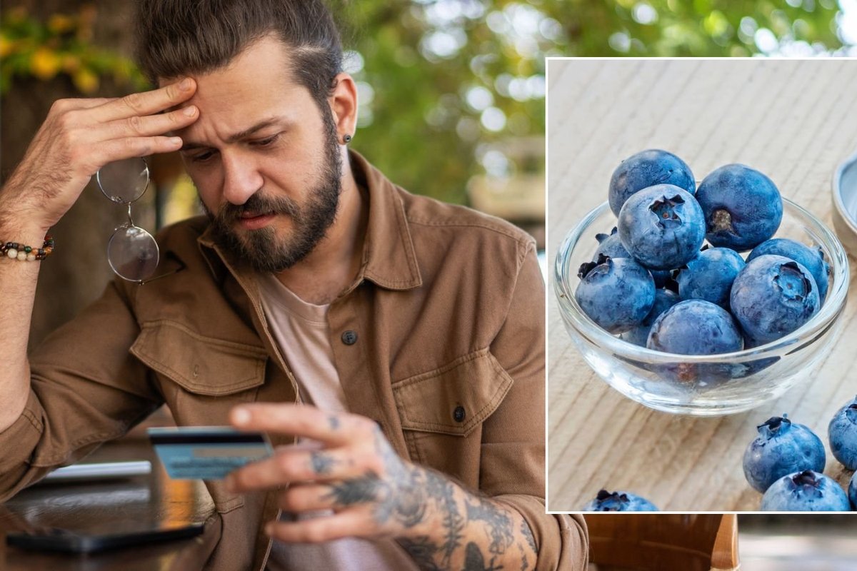 Man looking at bank card, blueberries
