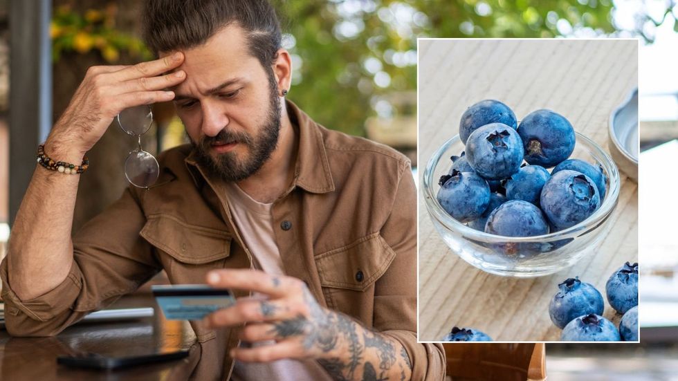 Man looking at bank card, blueberries
