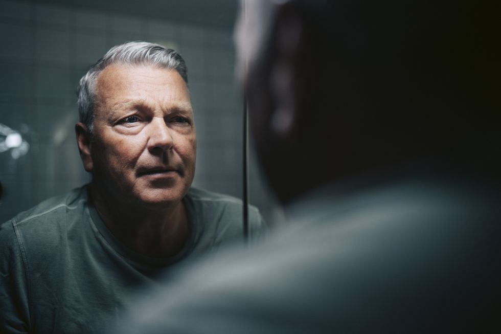 MAN LOOKING AT MIRROR