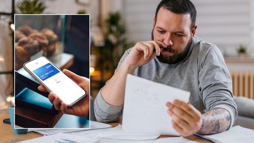 Man looking at paper and paying using bank card