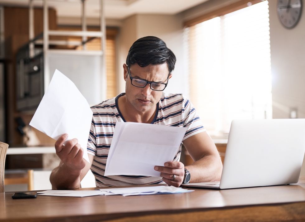 MAN LOOKING AT TAX PAPER WORK
