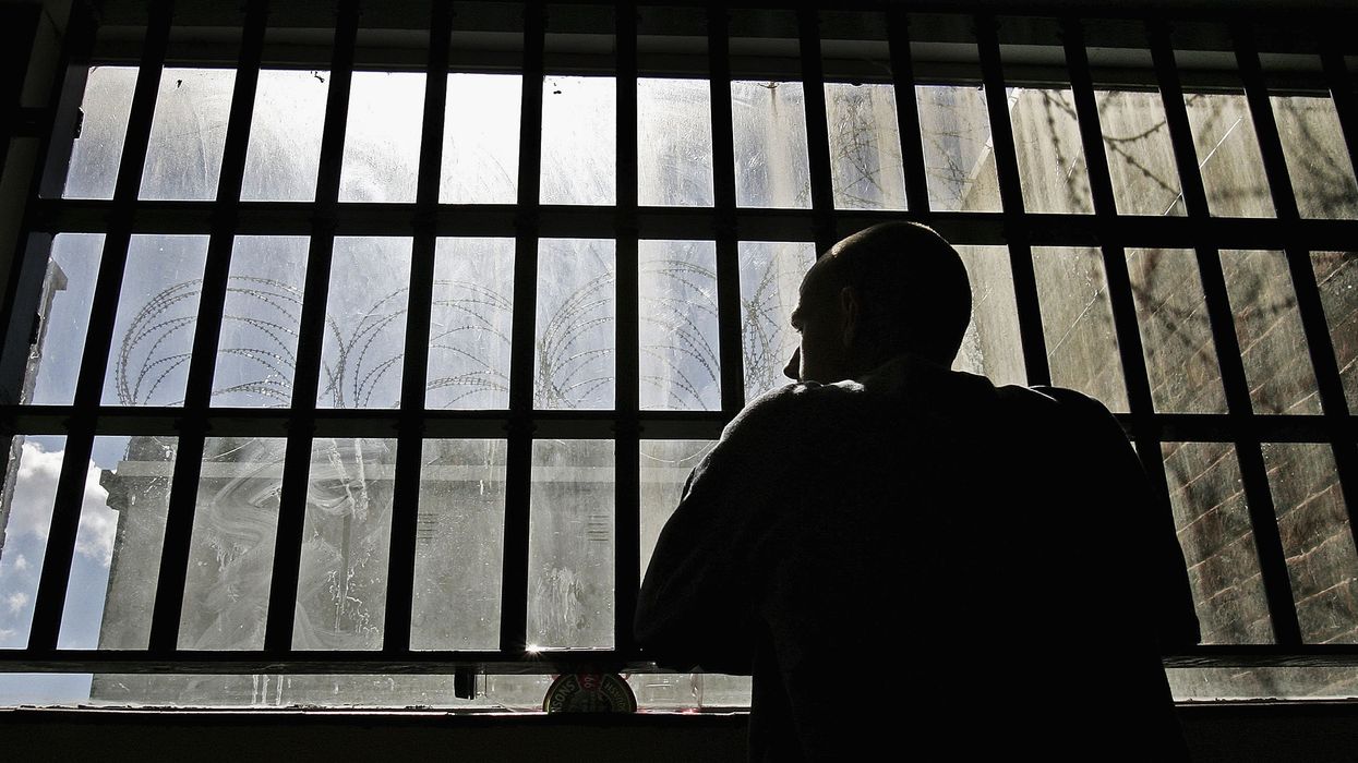 Man looking out barred window in British prison