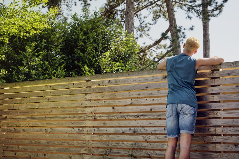 Man looking over the top of a fence