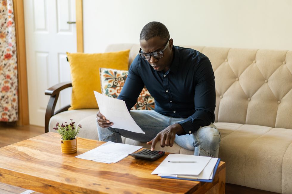 Man looks at calculator and documents