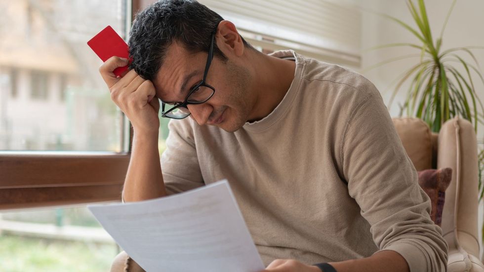 Man looks worried at debt holding bank card