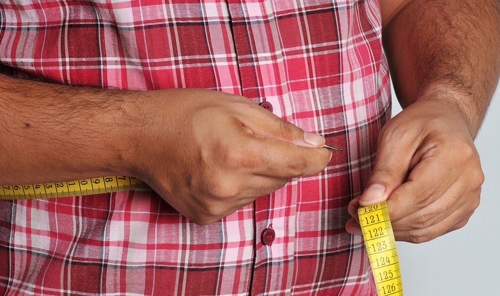 Man measuring his belly fat