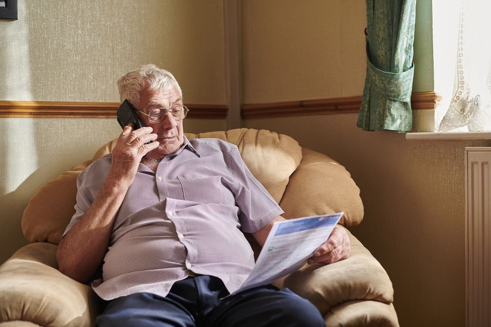 Man on phone while looking at energy bill