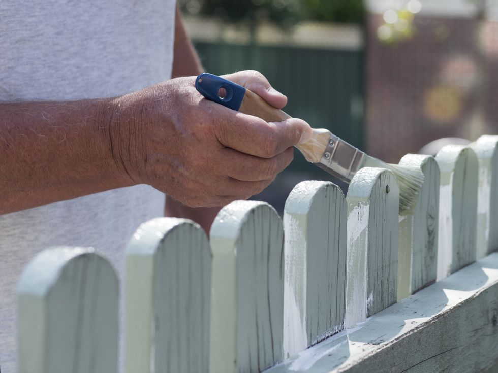 Man painting a fence