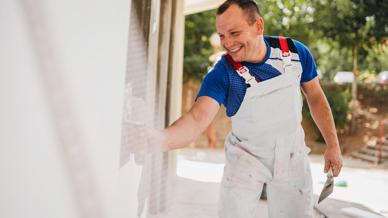Man painting wall of house