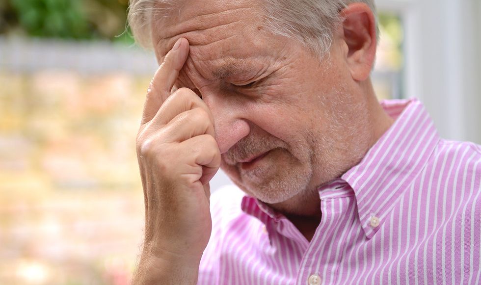 Man pressing his forehead in discomfort