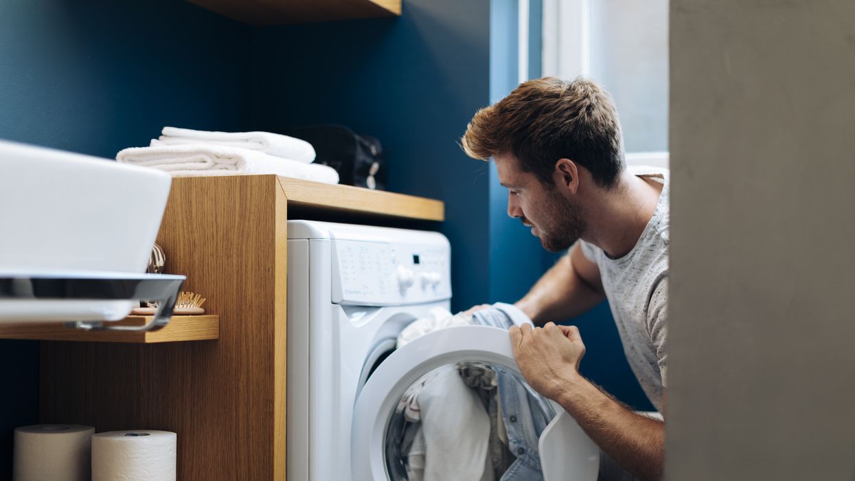 Man puts laundry into washing machine