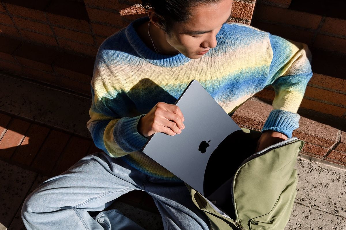 man putting a macbook air midnight into a bag