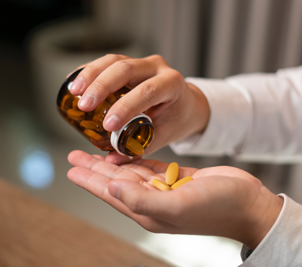 Man putting multivitamins in his hand