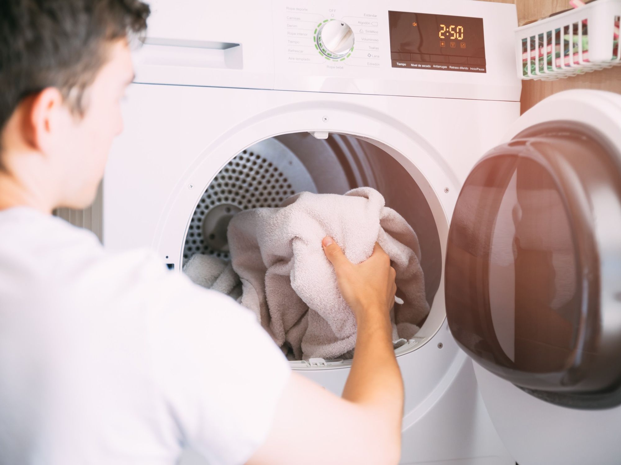Man putting towel in tumble dryer