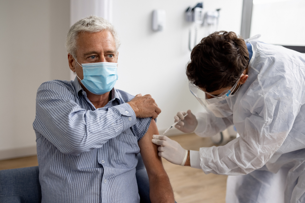 Man receiving a jab while wearing a surgical mask