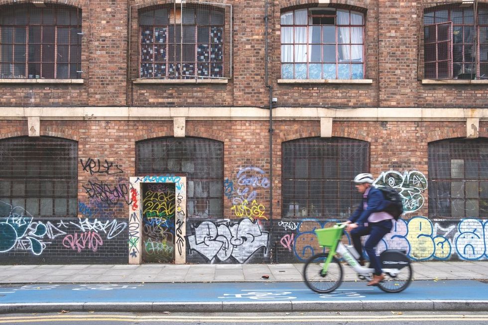 Man riding a bike on a cycle path in Shadwell, London