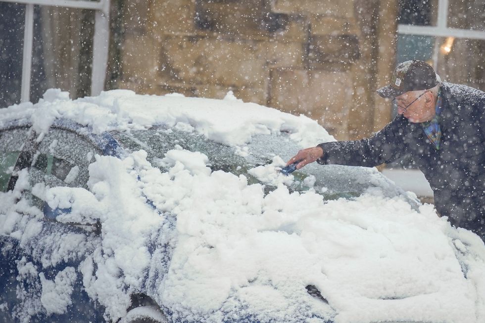 Man scraping snow of his car