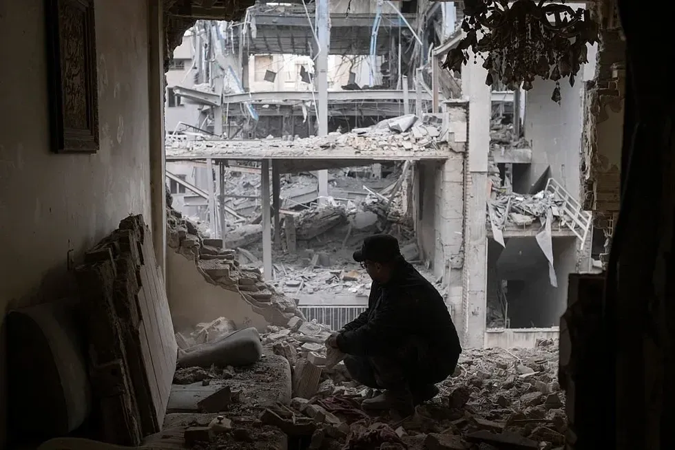 Man sitting in the wreckage of an Iranian strike