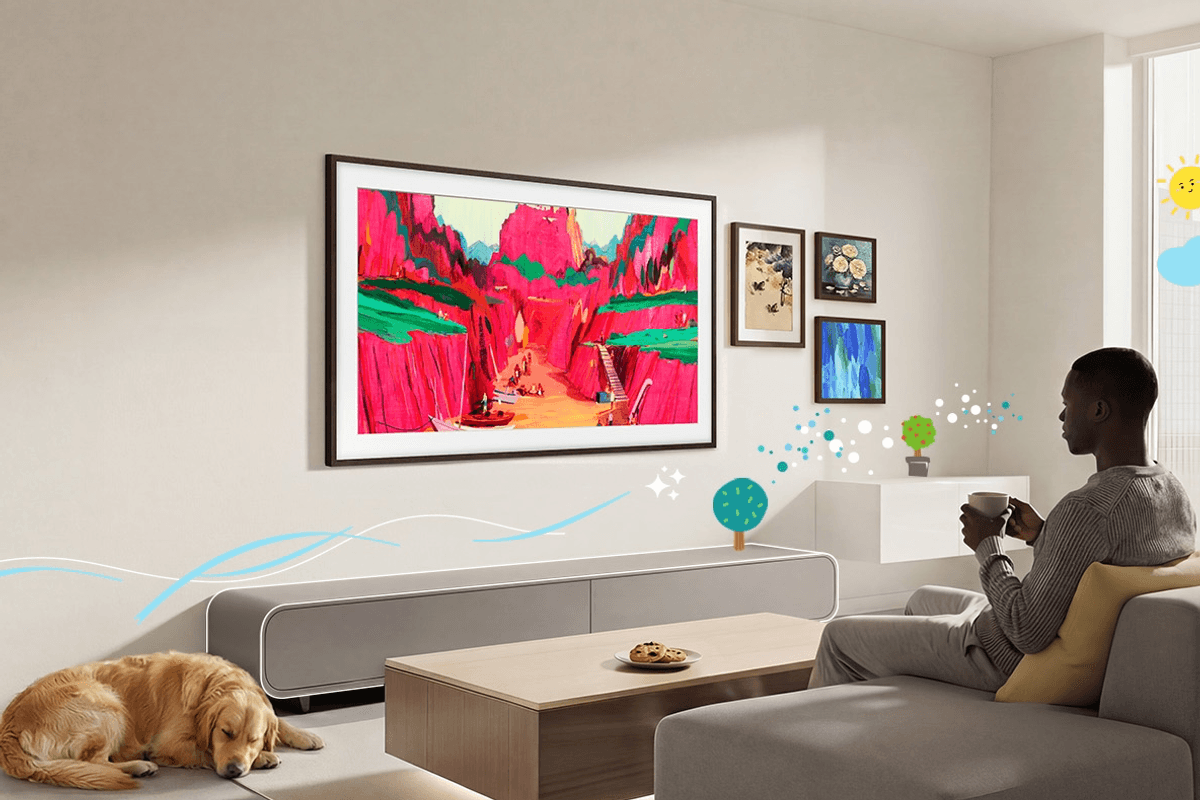 Man sitting with a cup of tea on the sofa watching artwork on the frame tv from samsung