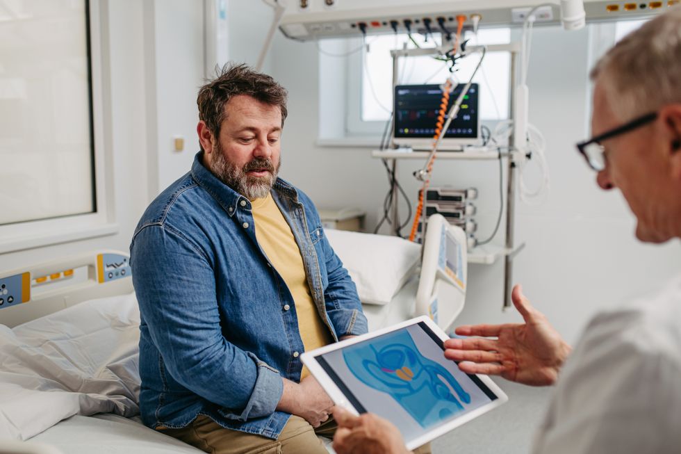 MAN SITTING WITH DOCTOR