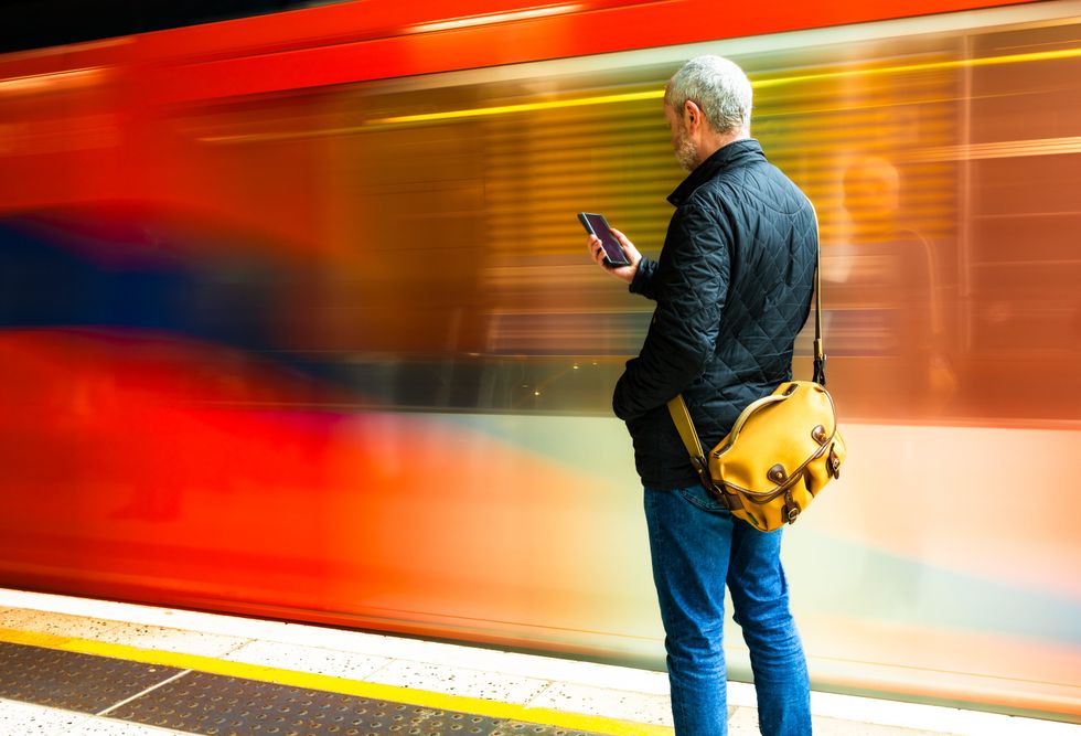MAN STANDING ON TRAIN PLATFORM