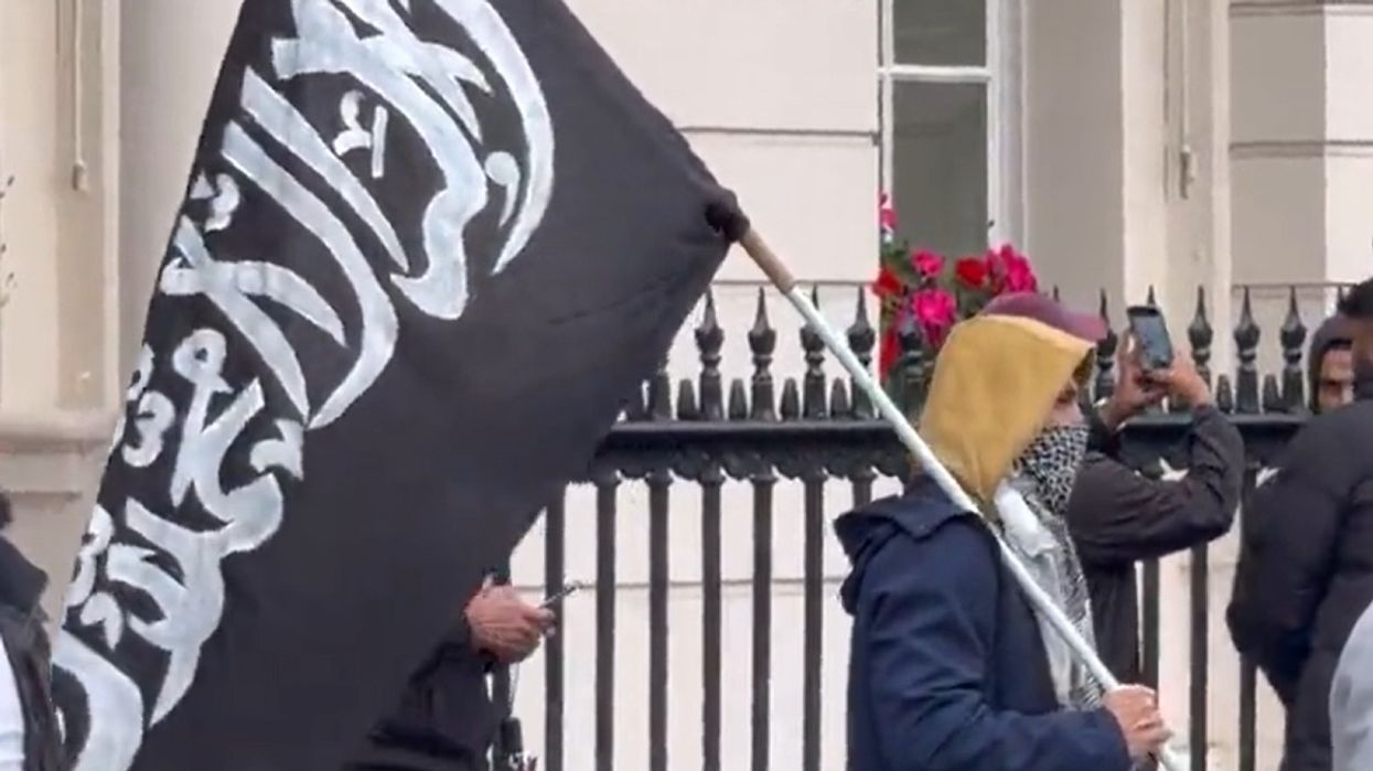 Man stands in London waving a flag of Jihad