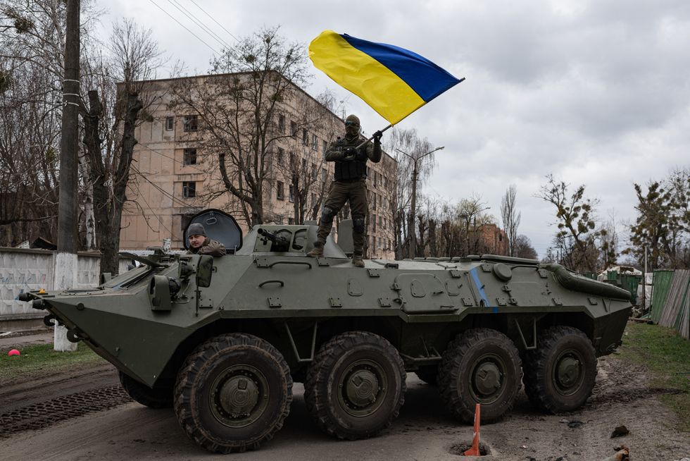 Man stands on a tank with a Ukraine flag