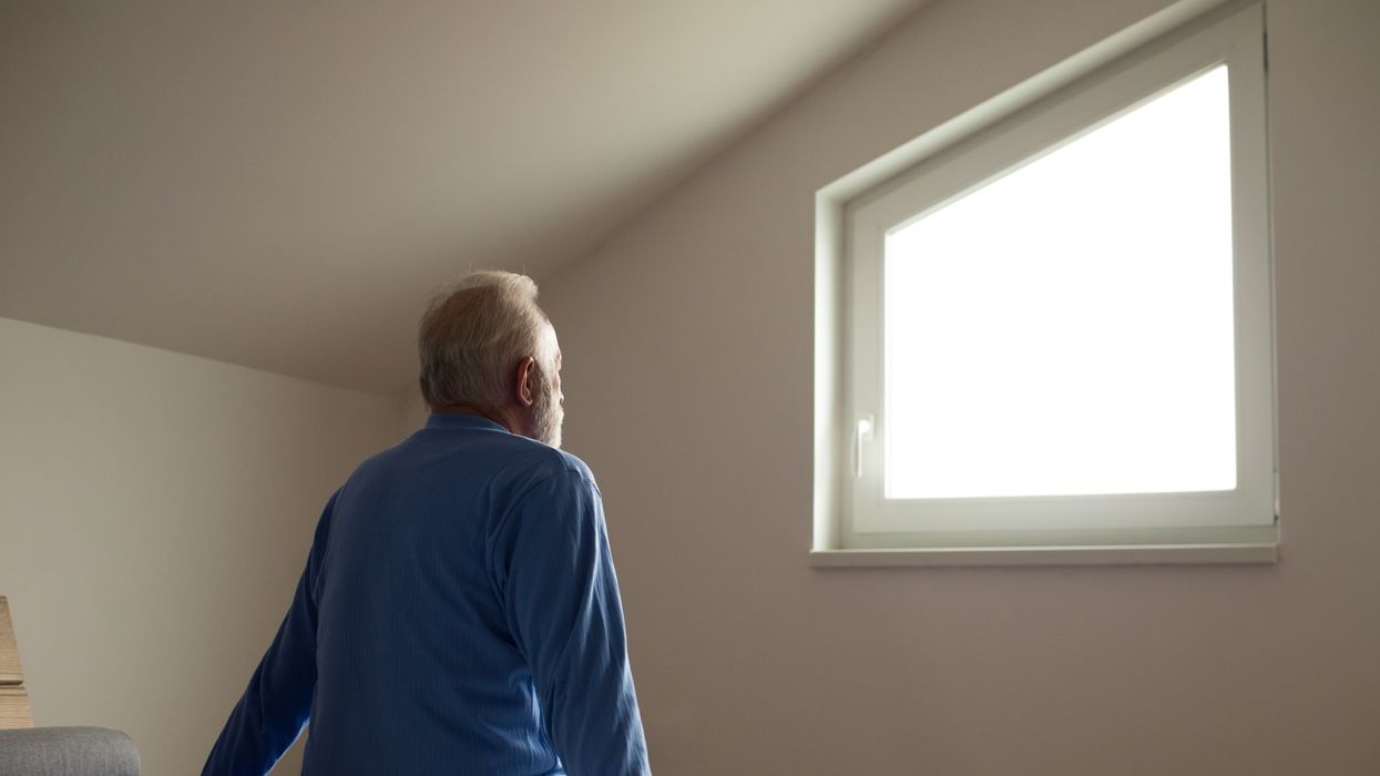 Man staring out the window after waking up in the morning