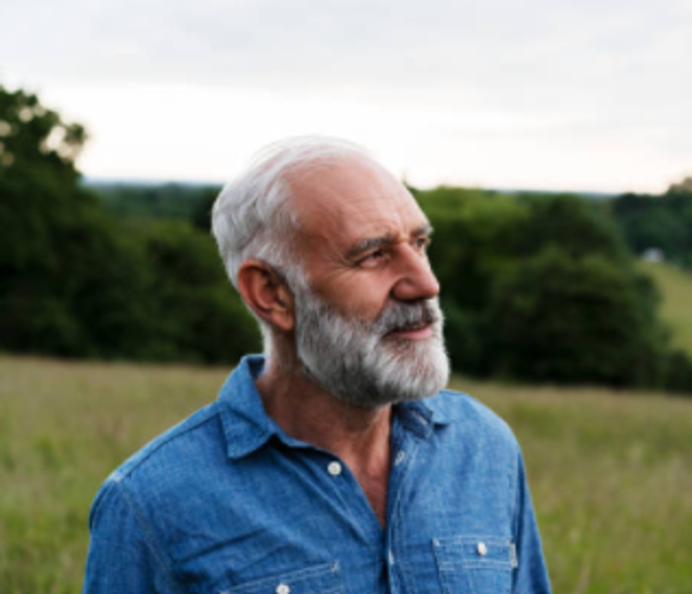 Man staring pensively across a field