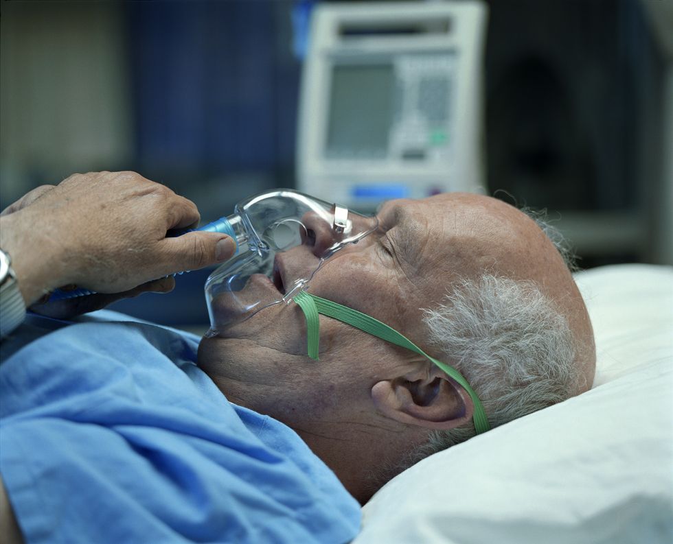 Man struggling to breathe in hospital bed