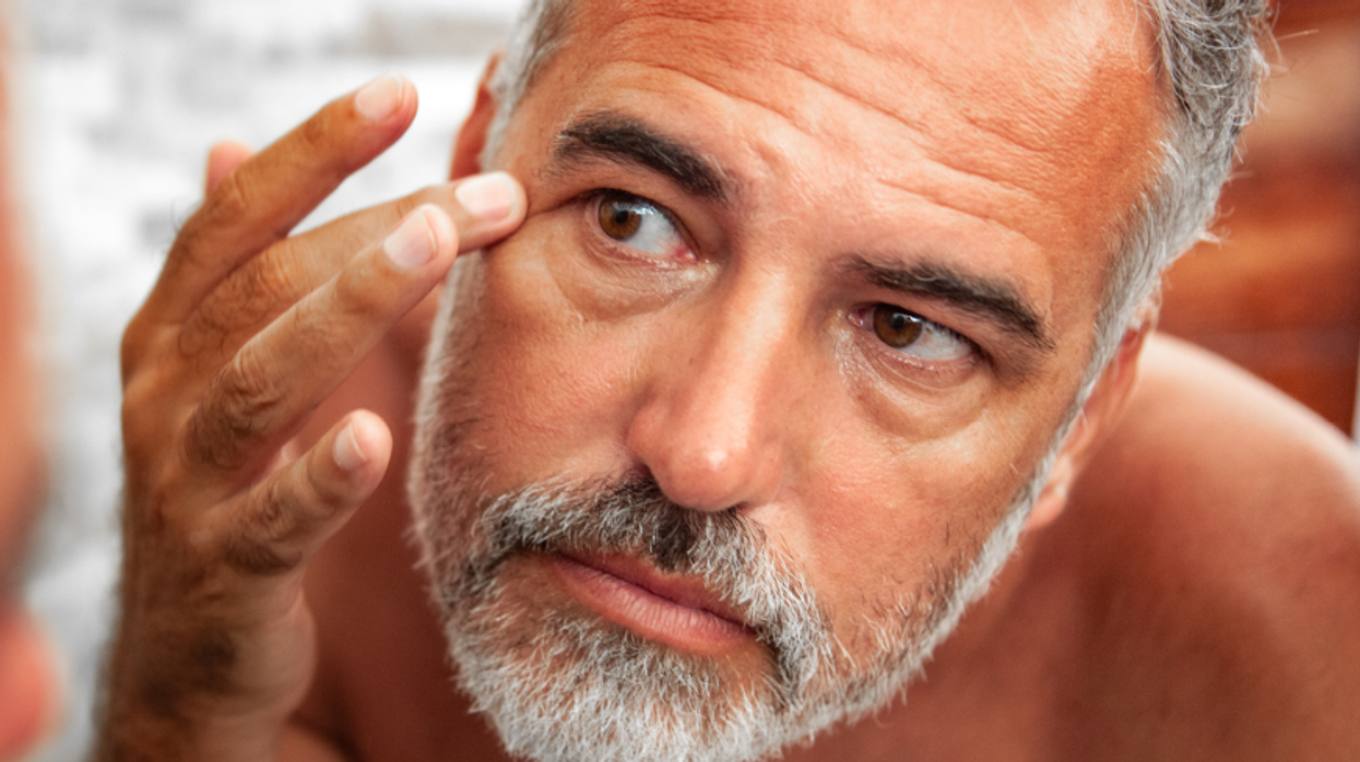 Man studying his eye in the mirror