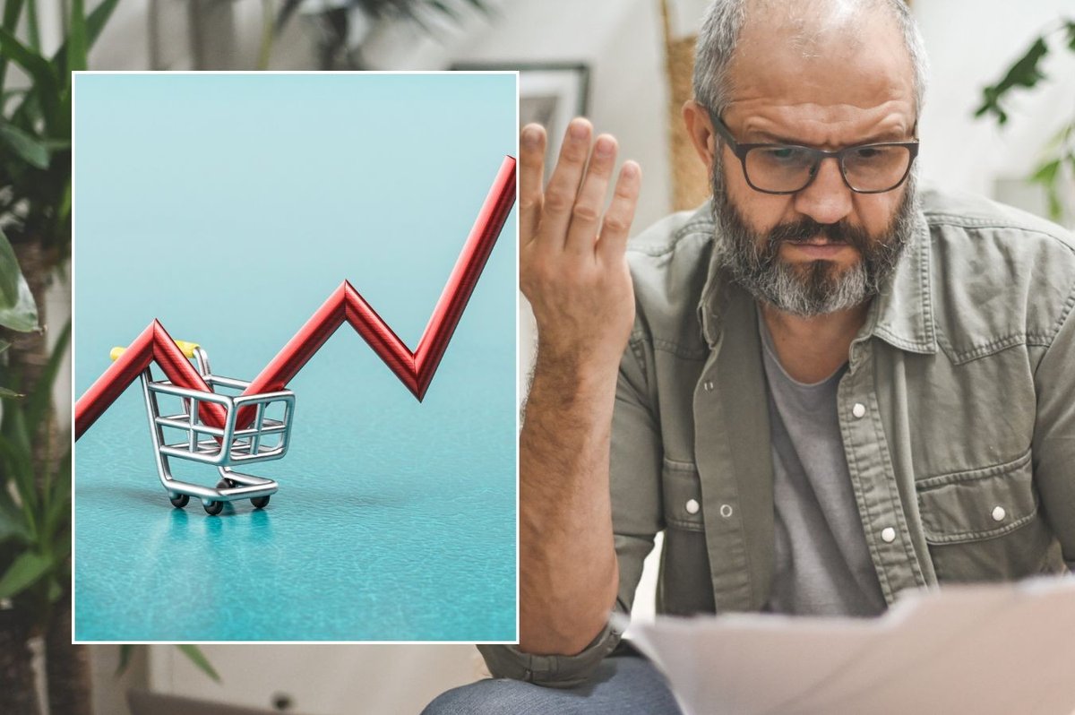 Man unhappy looking at payslip and inflation graph pointing up