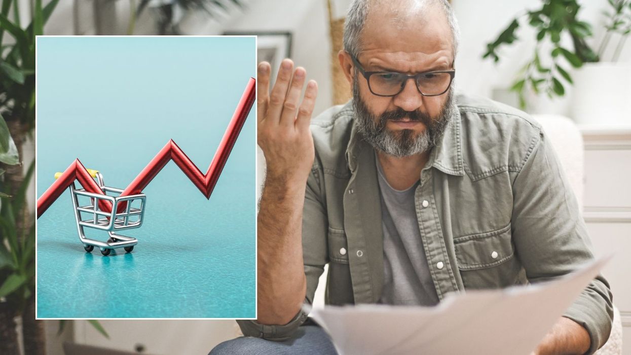 Man unhappy looking at payslip and inflation graph pointing up