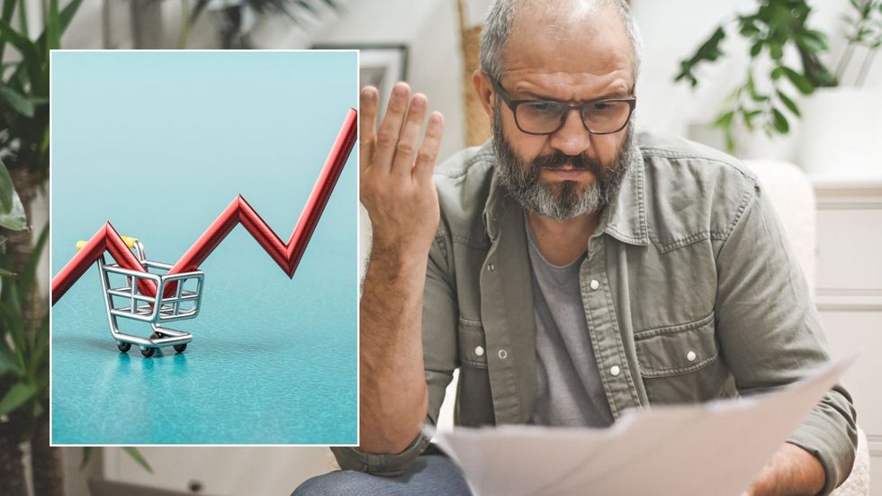 Man unhappy looking at payslip and inflation graph pointing up
