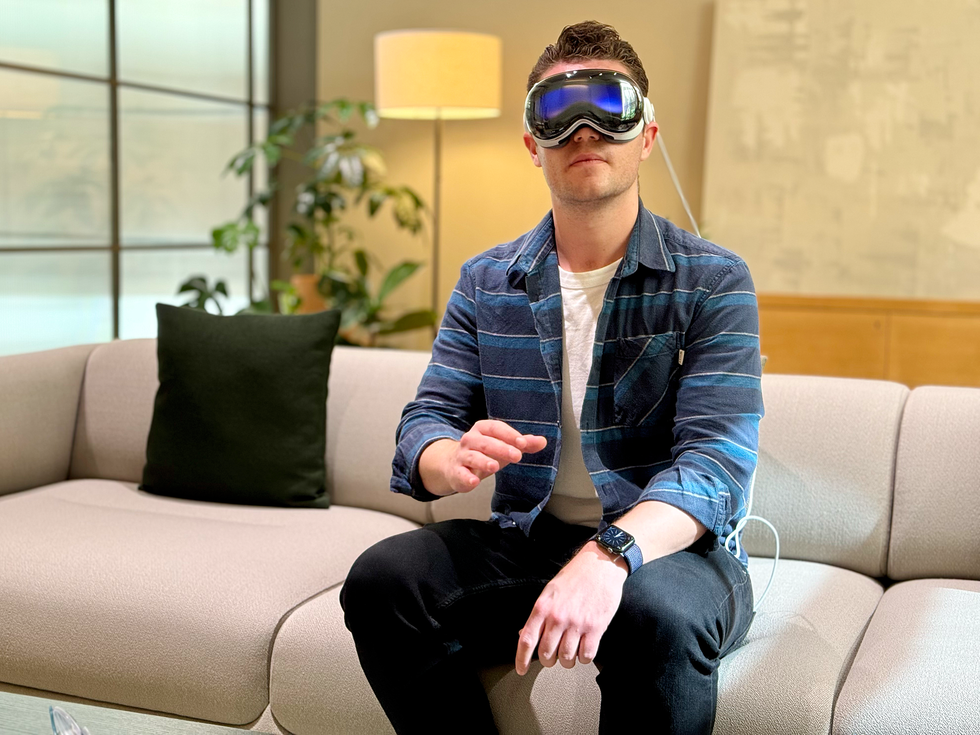 man using apple vision pro on a sofa