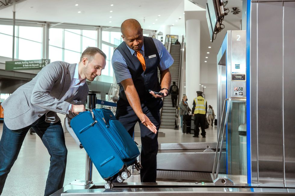 Man weighing suitcase