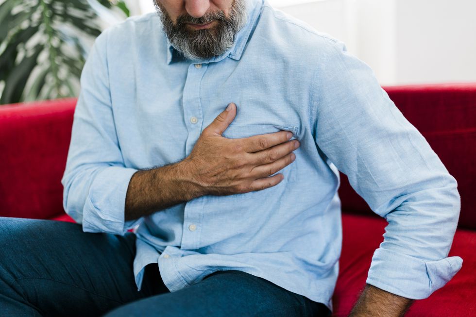 MAN WITH HAND ON CHEST