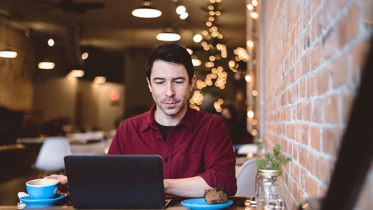 Man works from laptop in cafe