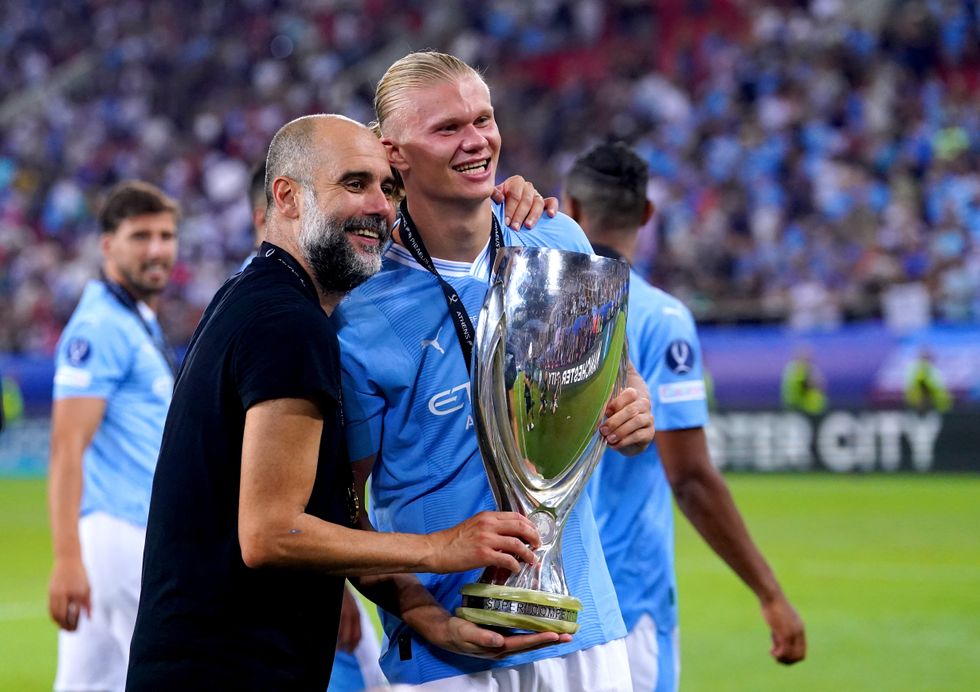 Manchester City's Erling Haaland (right) and manager Pep Guardiola pose for a photo with the UEFA Super Cup trophy
