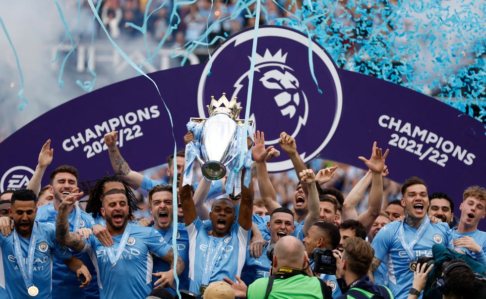Manchester City's Fernandinho lifts the trophy with teammates after winning the Premier League