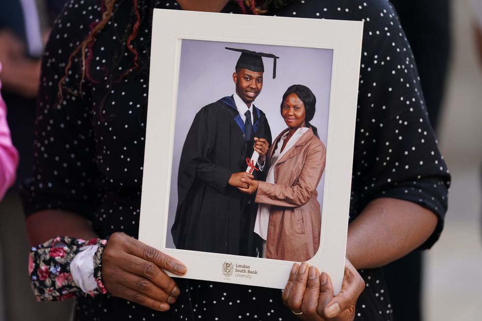 Marian Gomoh, the mother of David Gomoh, holds a graduation photograph of him outside the Old Bailey, London, after four gang members have been found guilty of the brutal killing of the innocent young NHS worker.