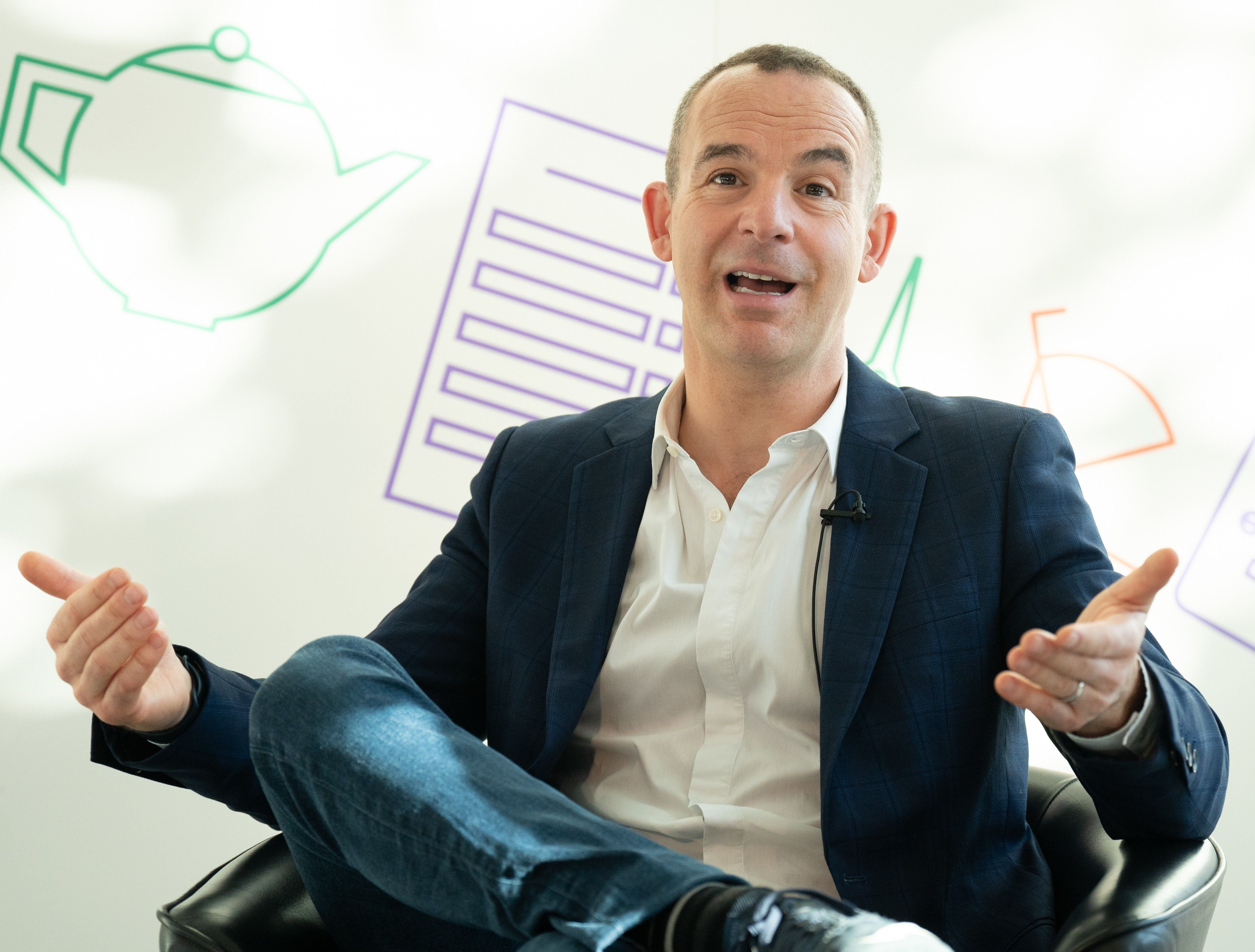 martin lewis sat in a leather chair talking at an event in london
